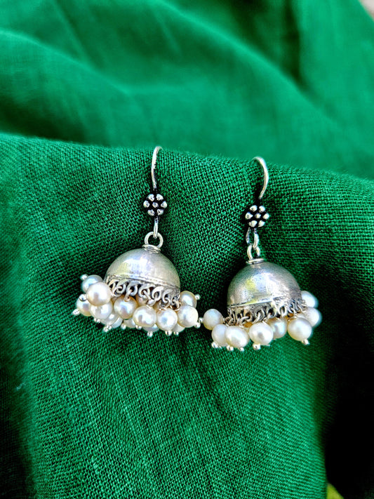 This is a small 925 Sterling Silver Jhumka with pearl drops. Lightweight and very easy to wear with the wire hook. It is made in pure silver by expert craftsmen of Jaipur, India. It is a traditional Indian bell shaped ethnic earring which goes well all Indian attires.