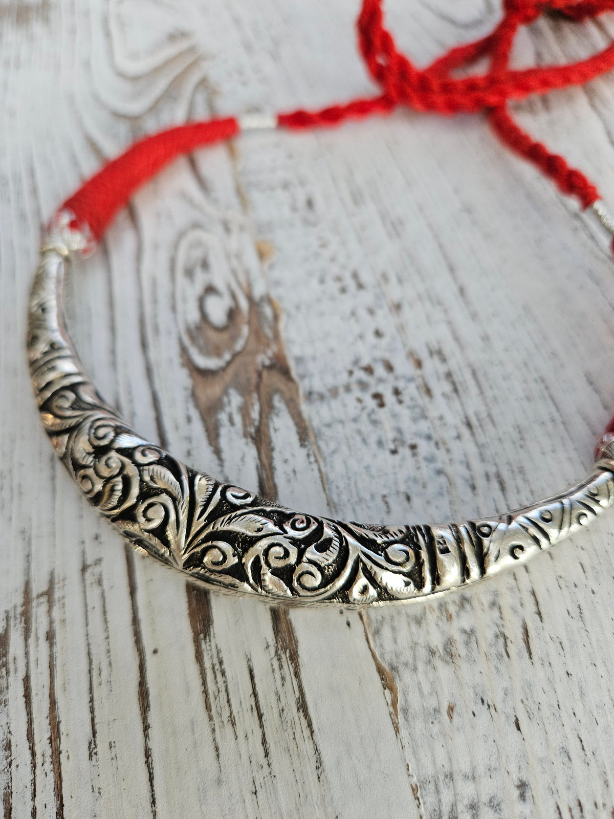 Handmade 925 oxidized sterling silver hasli necklace with chitai engraving and adjustable red cotton thread, on white wood