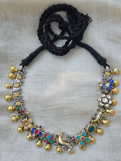 Dual-tone 925 sterling silver kundan charm necklace with parrot, fish, lotus, deer and bird motifs, gold drops and black thread tie, on ivory fabric