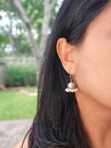 Model wearing our bestseller small silver jhumka earring.This is a small 925 Sterling Silver Jhumka with pearl drops. Lightweight and very easy to wear with the wire hook. It is made in pure silver by expert craftsmen of Jaipur, India. It is a traditional Indian bell shaped ethnic earring which goes well all Indian attires.